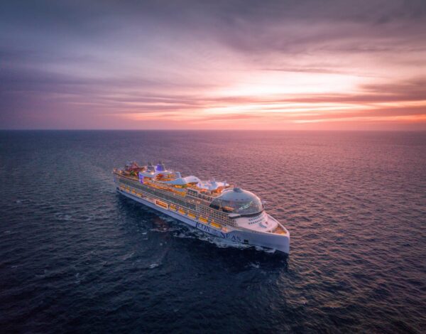 Aerial sunset view of Icon of the Seas sailing toward the camera