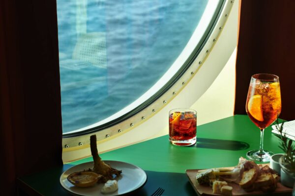 Food and drinks on a table by a porthole window at Extra Virgin. UK Photoshoot / Atlantis Shoot Dates: Sept 27-30, 2021 Usage: Full Buyout Goal: Food & Beverages Deliverables: images, gifs, and videos TEAM Photographer: Scott Grummett https://www.scottgrummett.com Agent: Terri Manduca Food Stylist / AD: Elisa Merlo CD: Christian Schrader Art Buyer / Producer: Kathy Boos